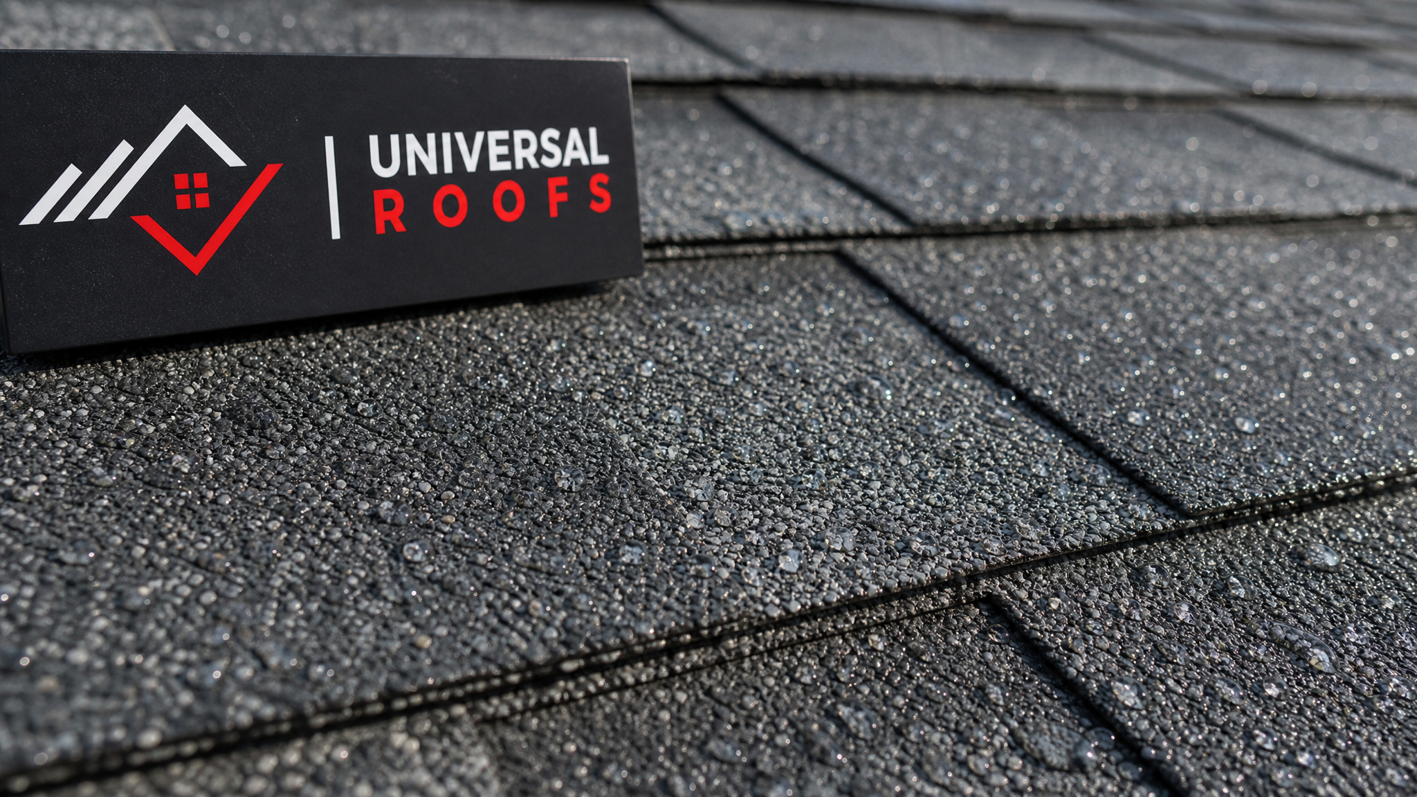 Close-up of clean asphalt shingle texture showing intact granules after soft-wash cleaning, with a small branded sign placard resting nearby