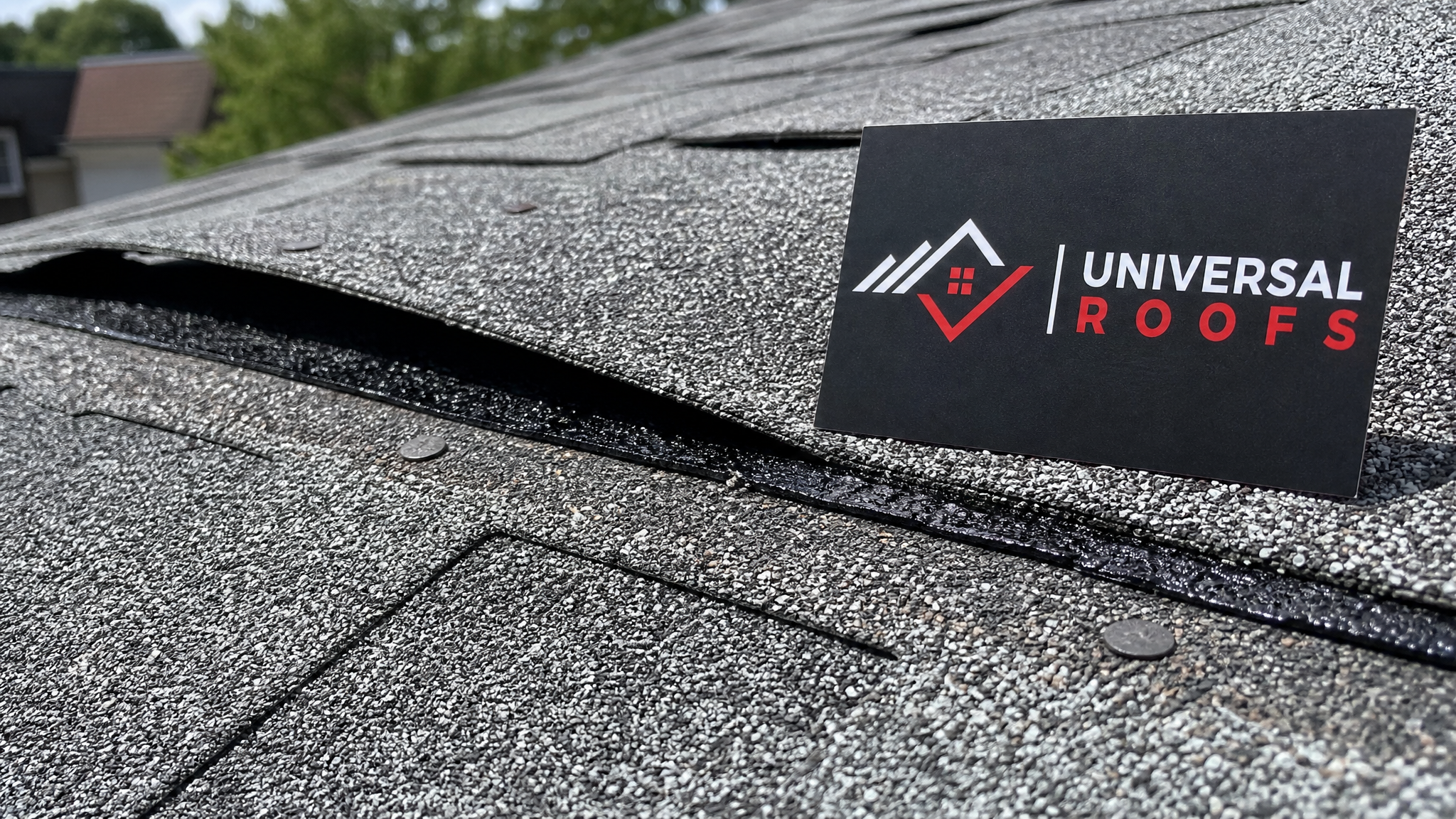 Close-up of overlapping asphalt shingle courses showing proper nail placement and sealant strip bond