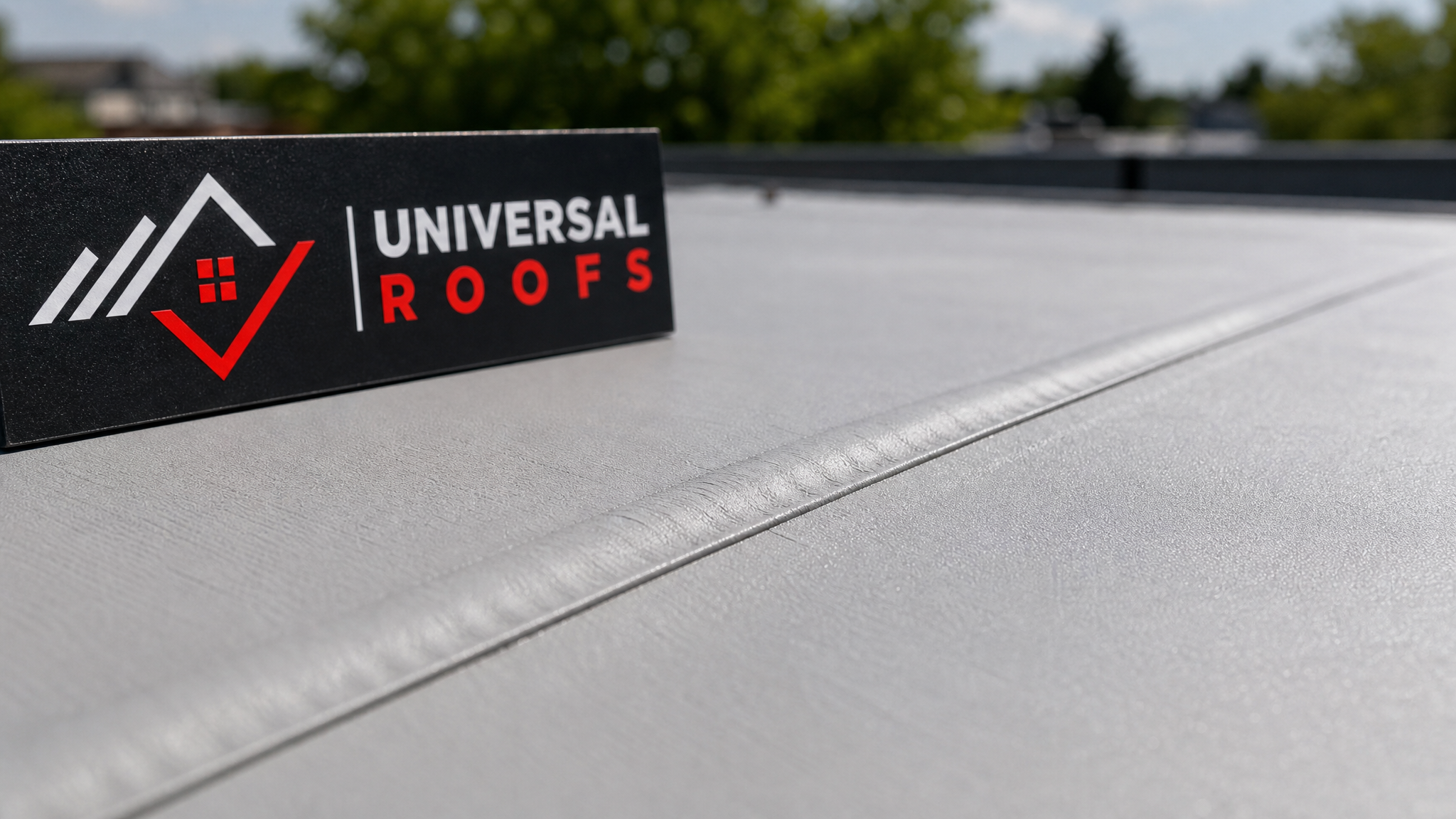 Close-up of a heat-welded seam on a TPO flat roof membrane with a Universal Roofs branded sign placard nearby