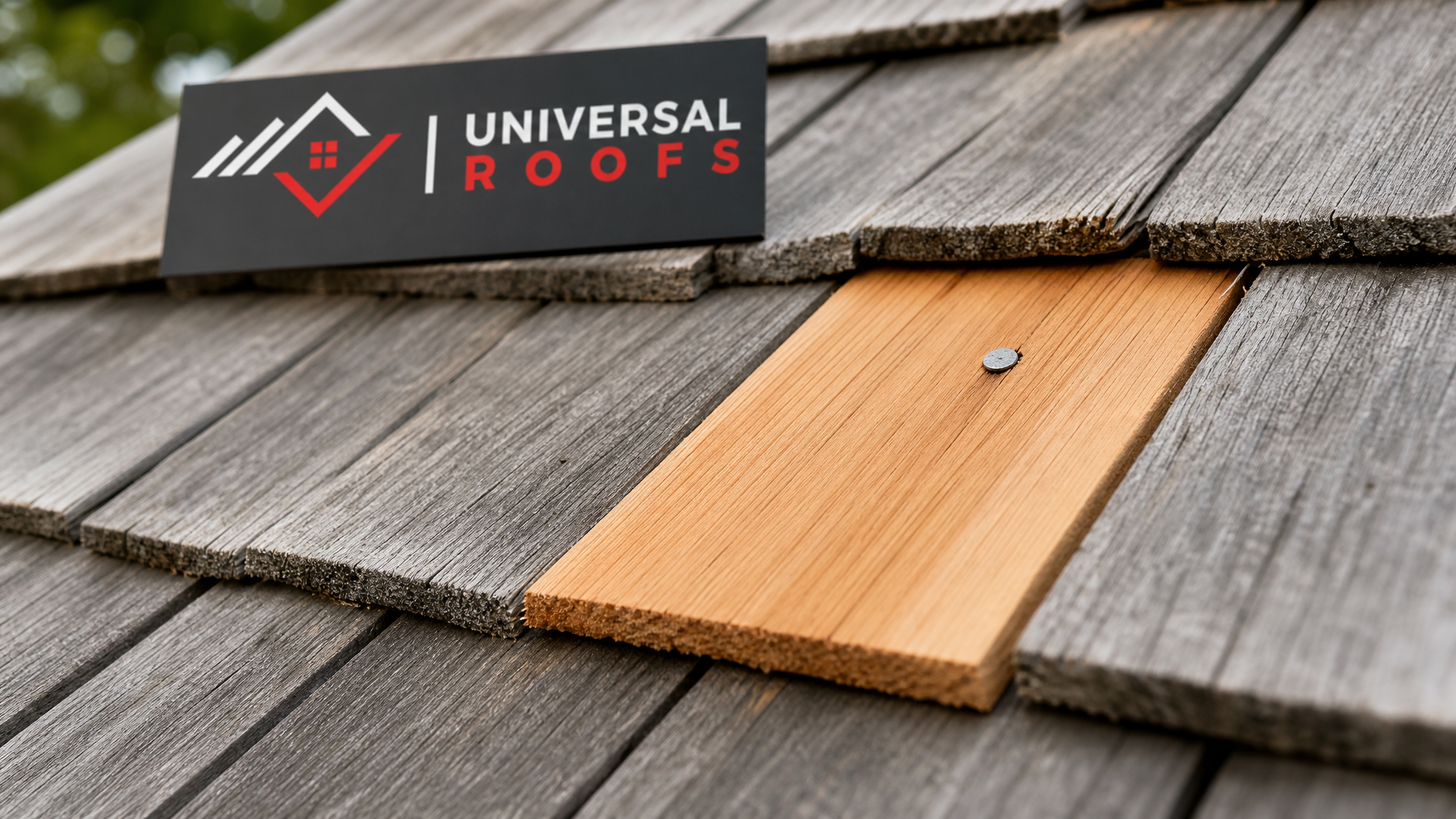 Close-up of a new cedar shake matched into an existing course after hail damage repair, showing grain and fastening detail