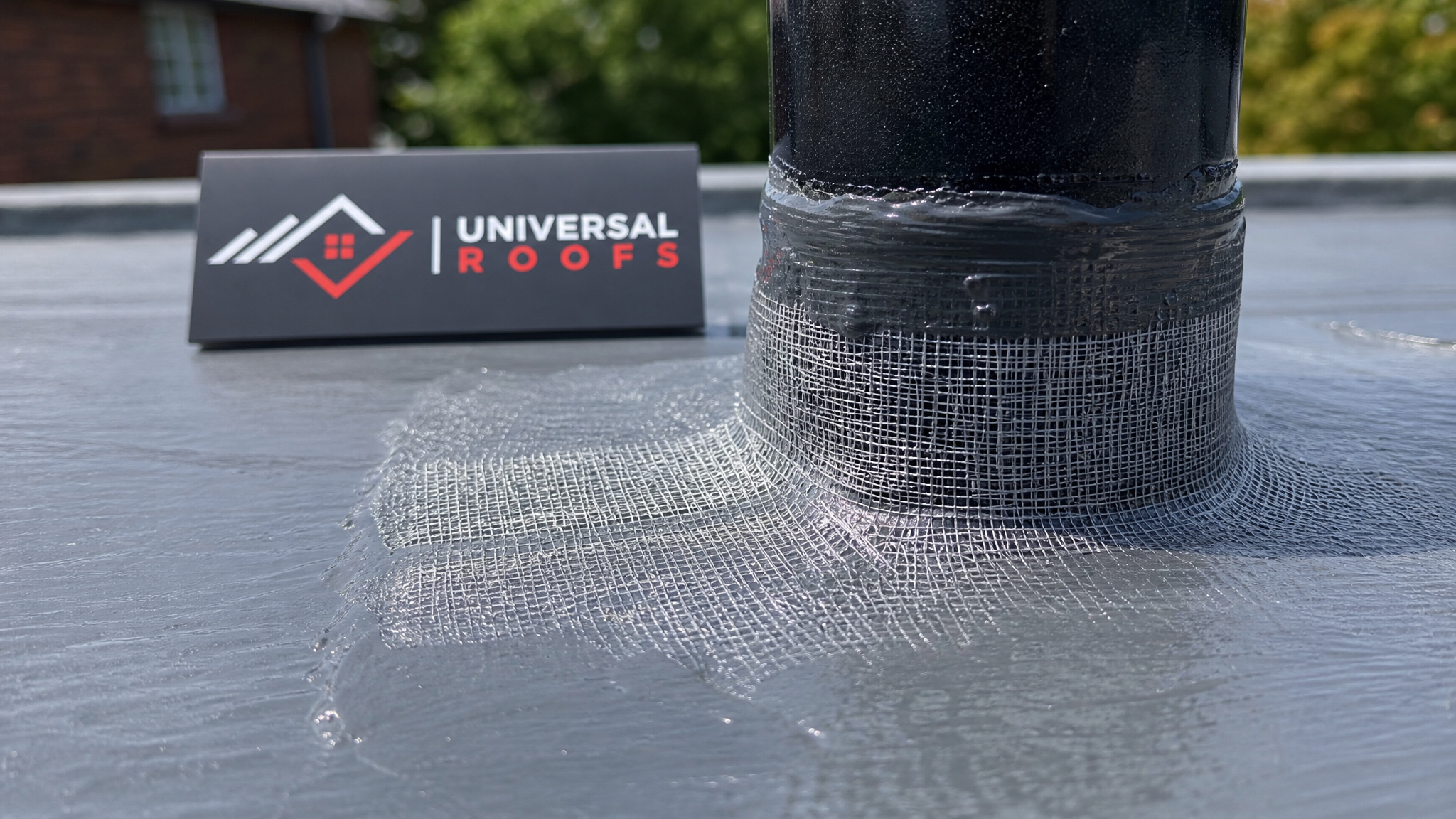 Close-up detail of a reinforced roof coating seam with fabric mesh embedded around a flashing detail on a Toronto flat roof