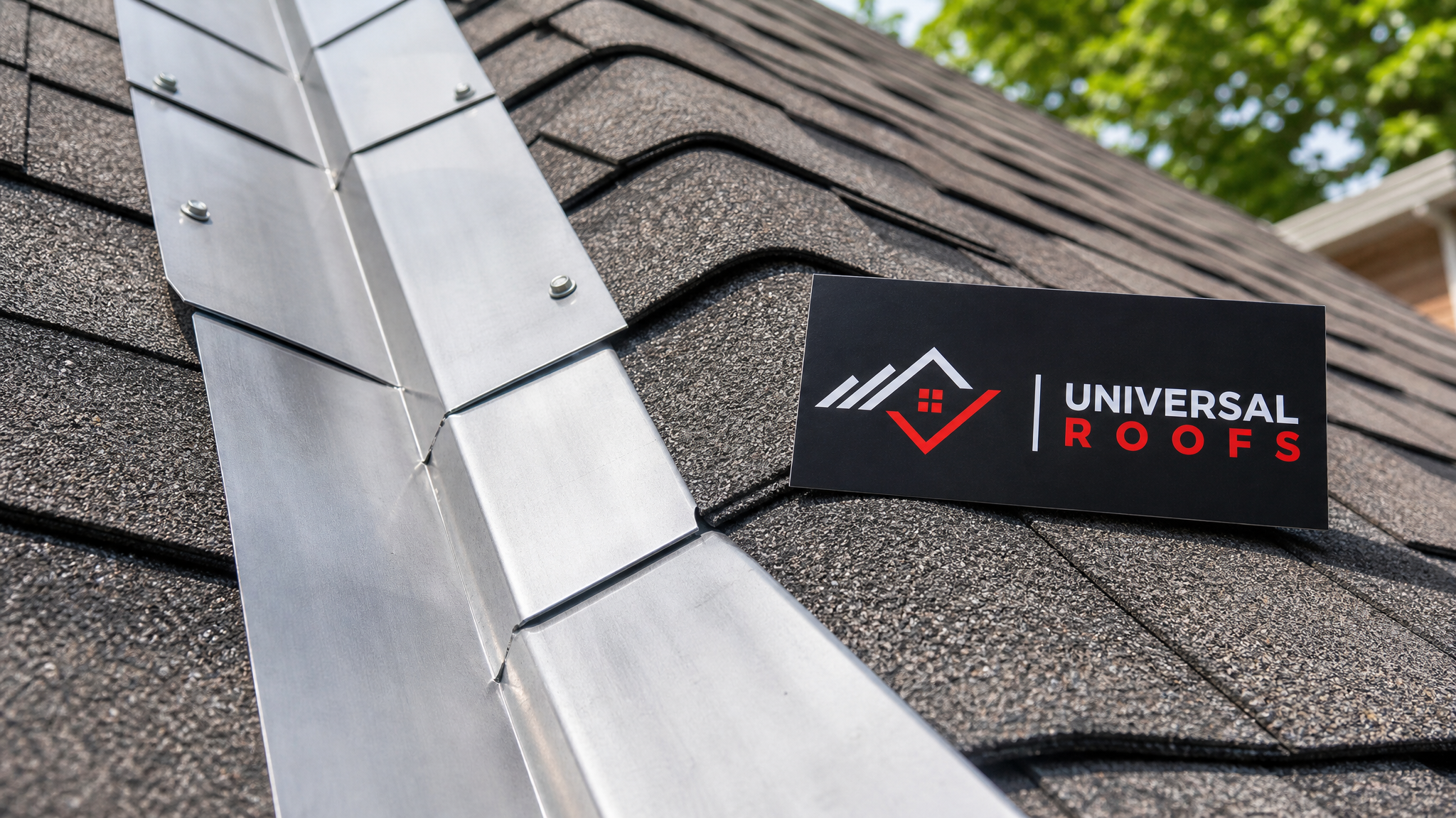 Close-up detail of new aluminum step flashing overlapping shingle courses with a Universal Roofs branded sign placard nearby