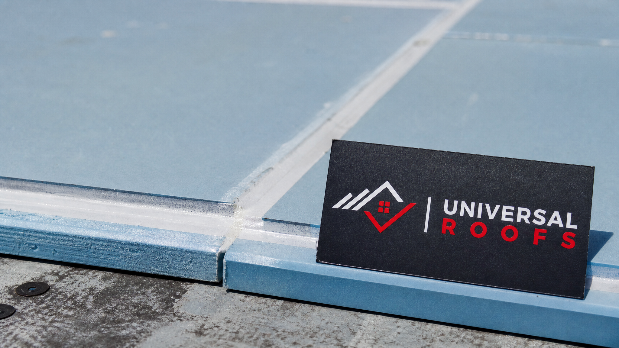 Close-up detail of rigid foam insulation board seams taped and sealed against a roof deck