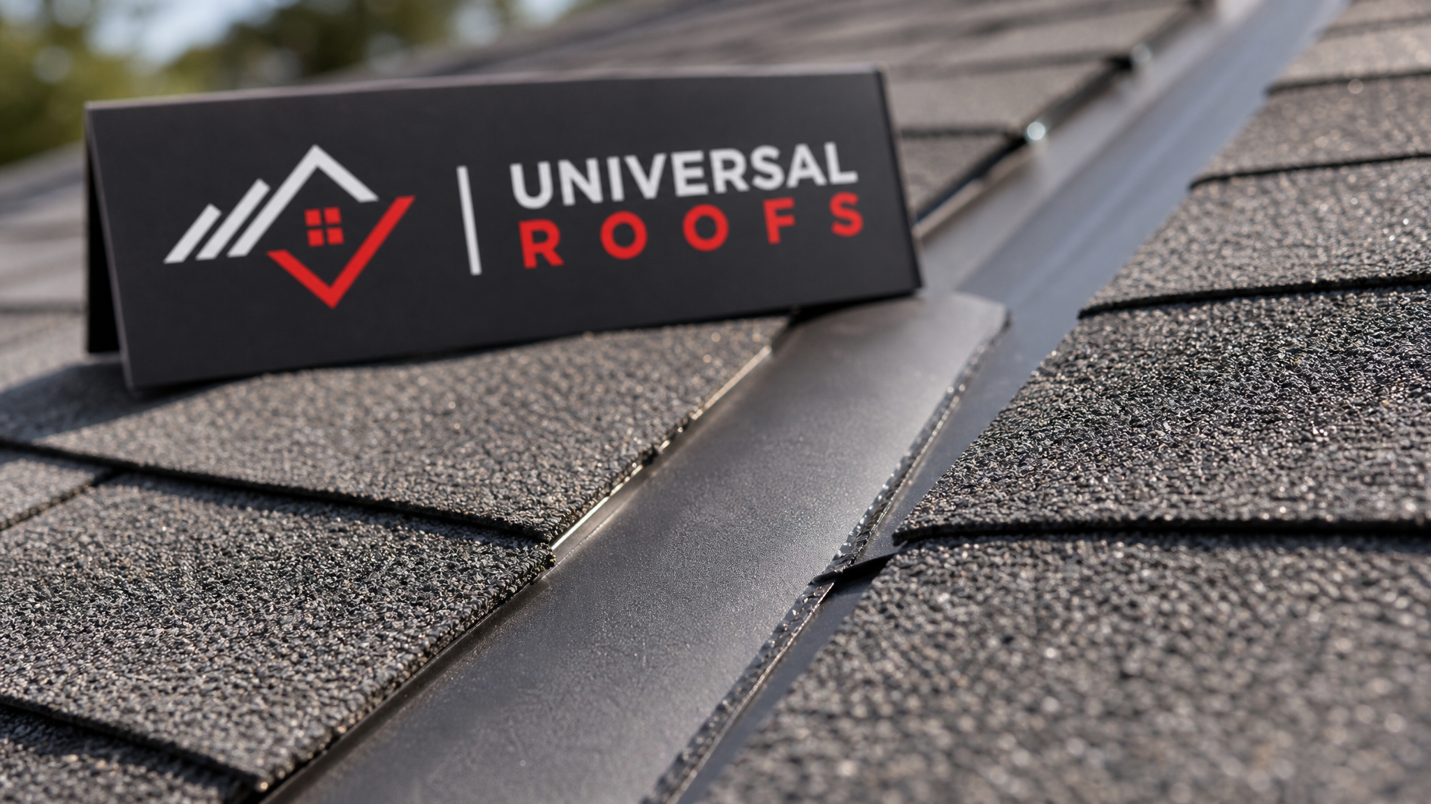 Close-up of asphalt shingle edges and metal flashing at a roof valley showing granule texture and seam detail