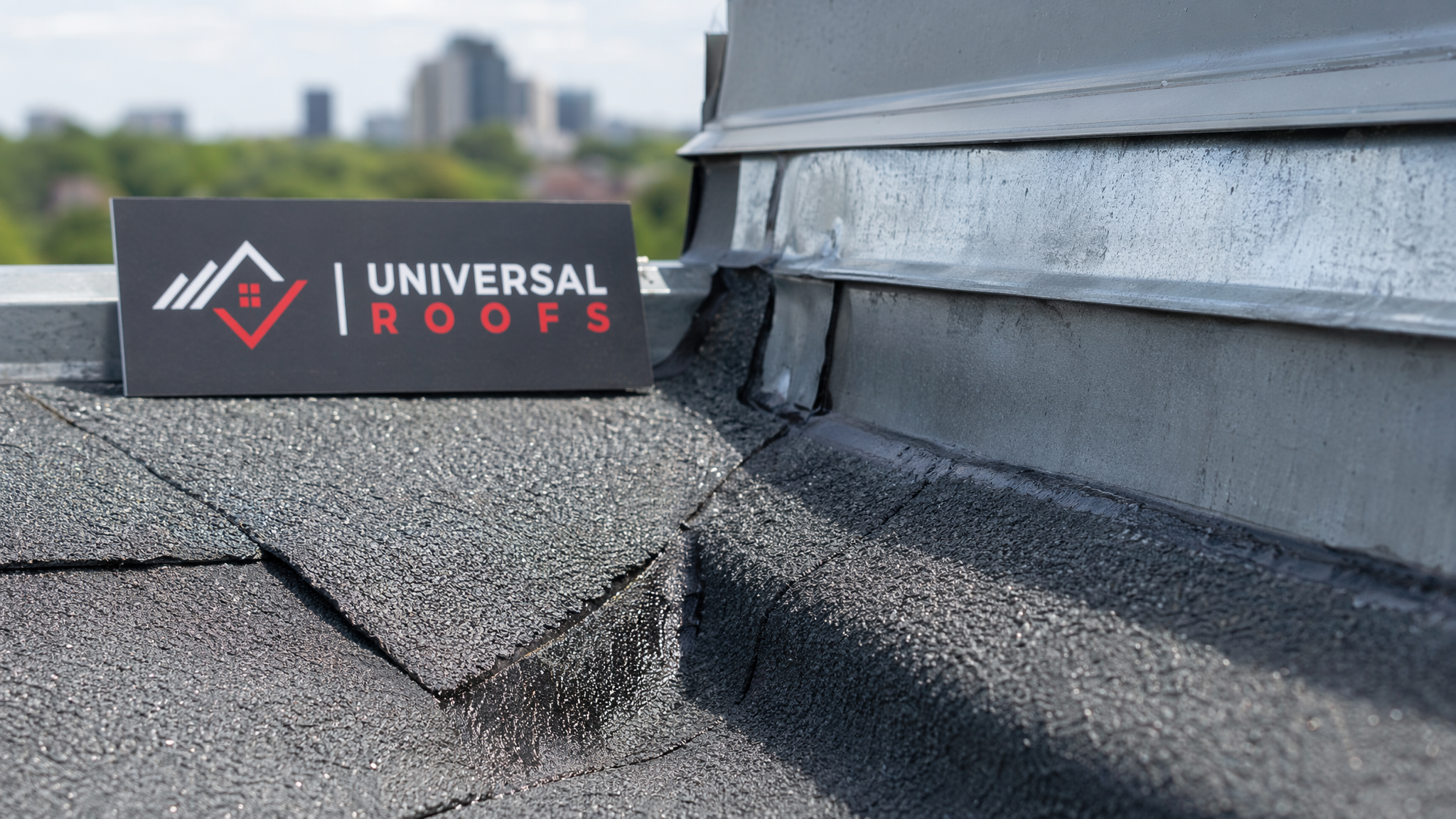 Close-up of overlapping rubberized waterproofing membrane and metal flashing at a roof valley seam
