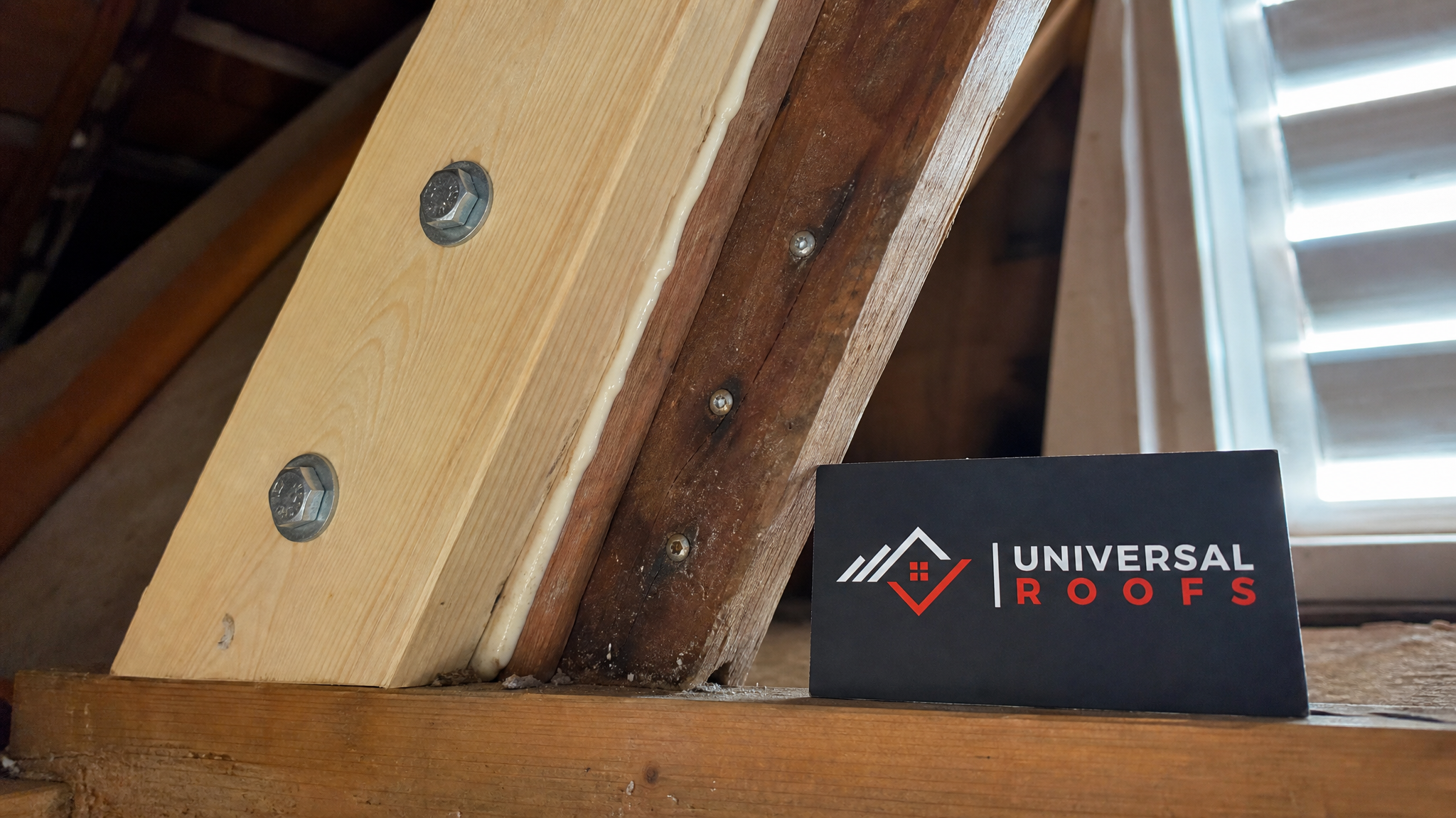 Close-up of a newly sistered rafter joint with structural screws and construction adhesive visible