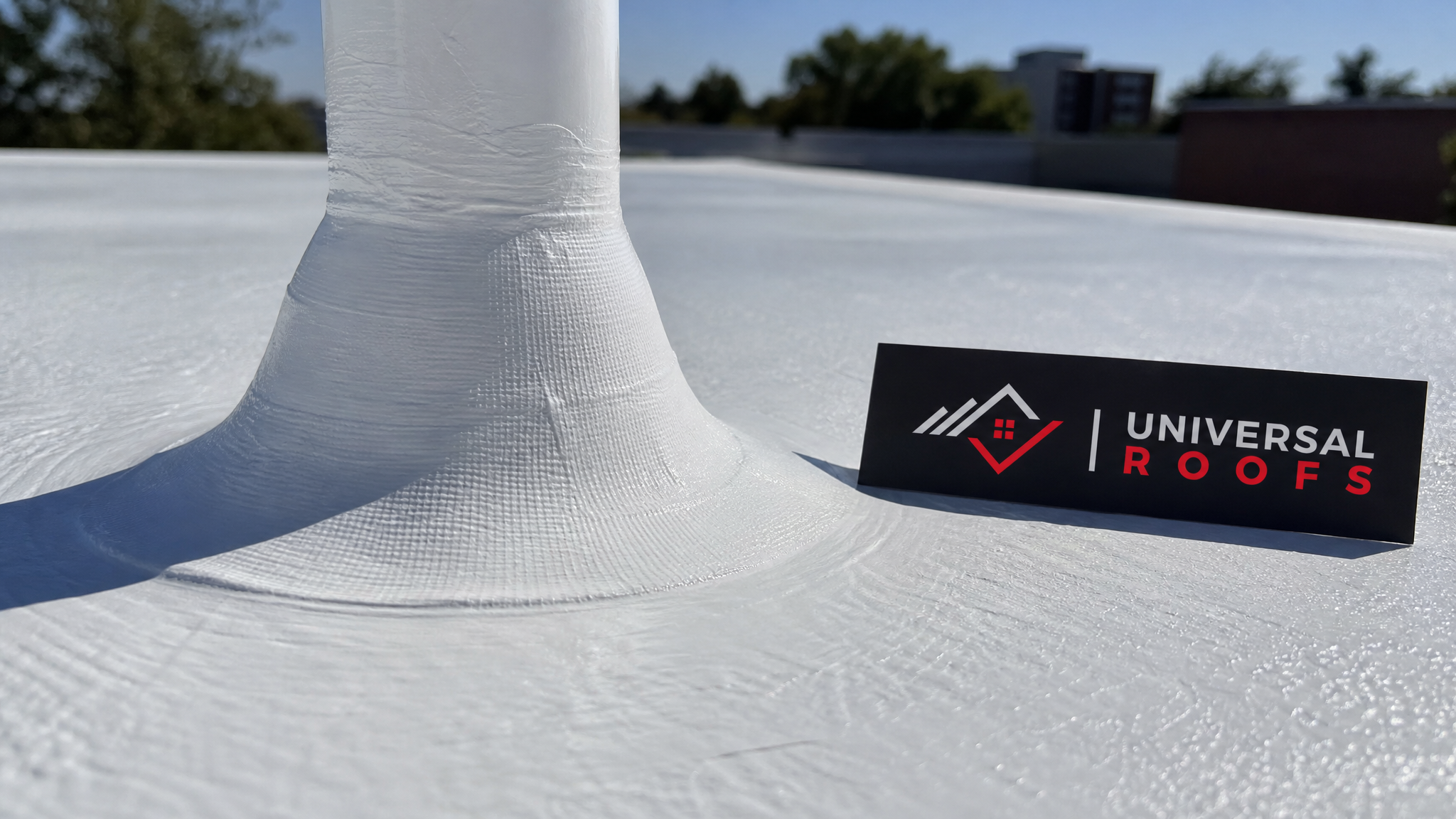 Close-up of seamless white silicone roof coating showing reinforced seam detail around a roof drain
