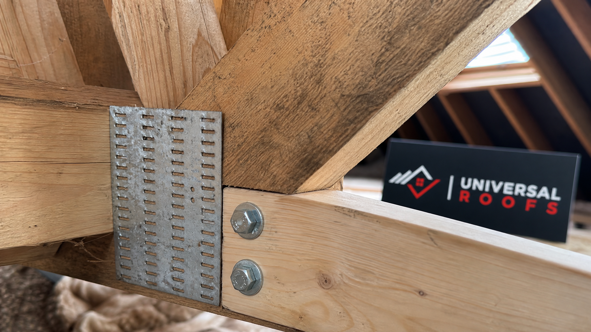 Close-up detail of a reinforced truss connector plate and sistered lumber joint showing proper fastener pattern in a Toronto attic