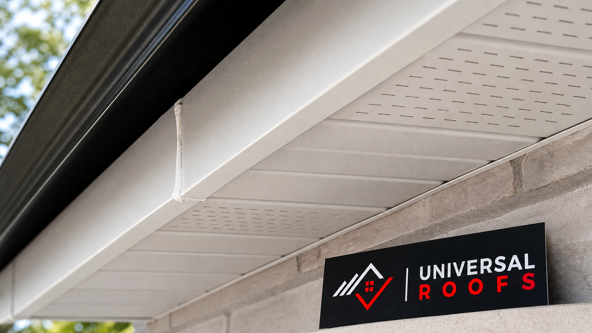 Close-up of new vented aluminum soffit panel and fascia joint detail with sealant finish on a residential roofline