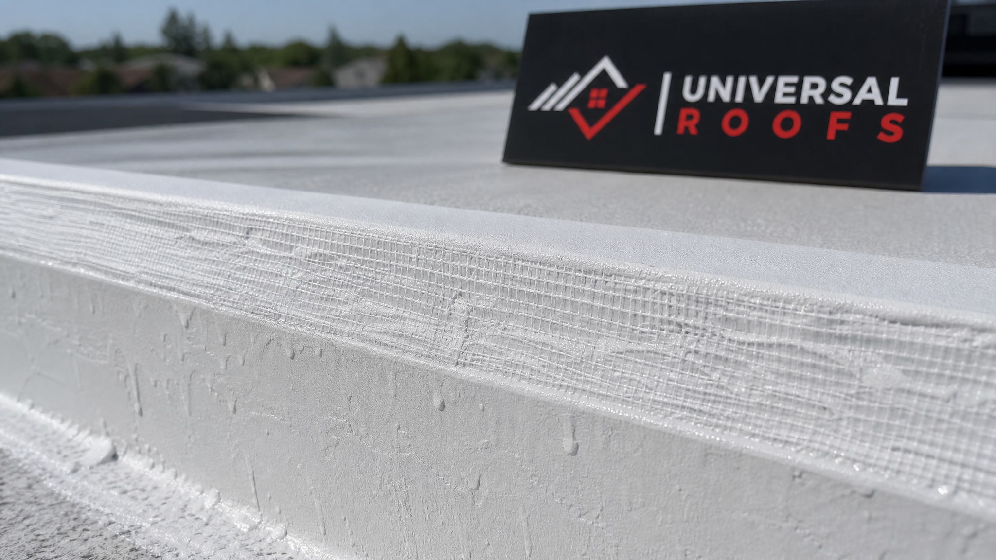 Close-up detail of a reinforced roof coating seam with embedded fabric mesh on a flat roof edge in Toronto