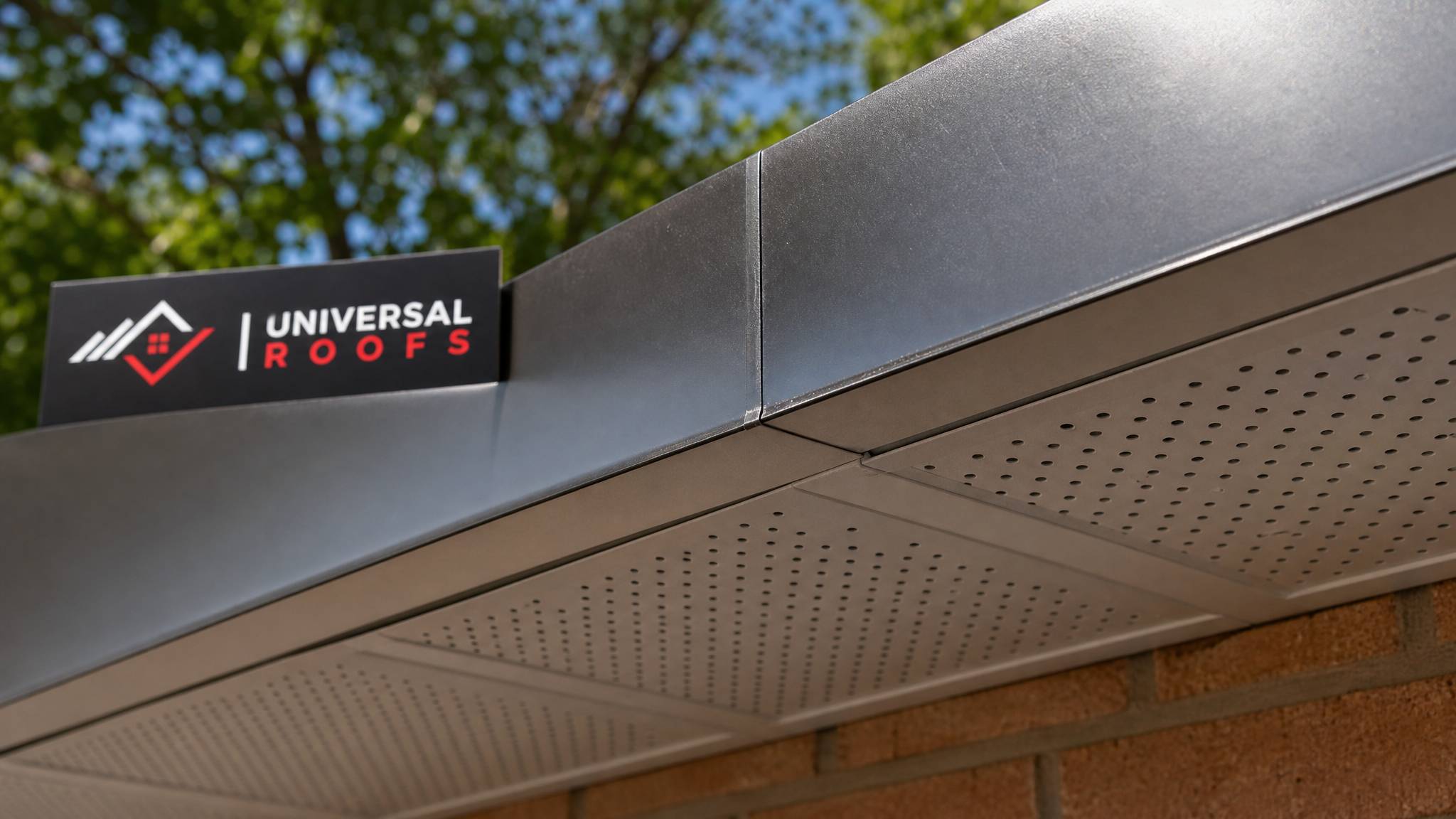 Close-up of vented aluminum soffit panel and aluminum-wrapped fascia joint with sealed seams, Universal Roofs branded sign placard visible nearby, Toronto summer daylight