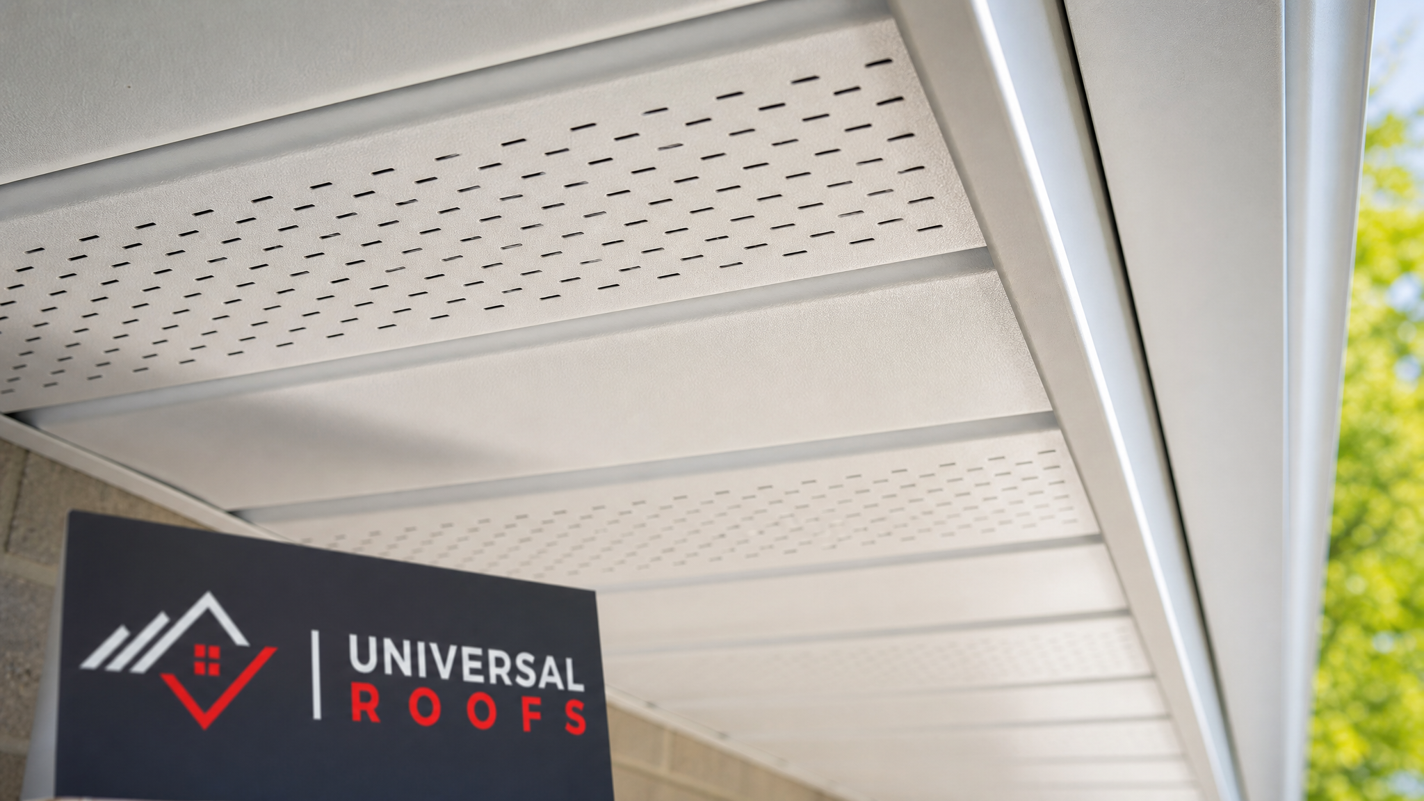 Close-up detail of new aluminum soffit vent panel installed under a roof overhang